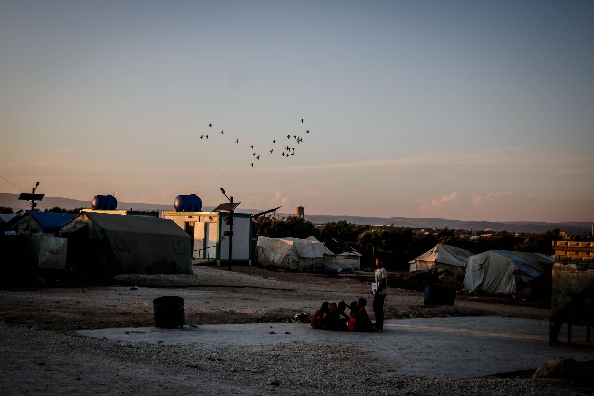 Illustrative photo: a displacement site at sunset