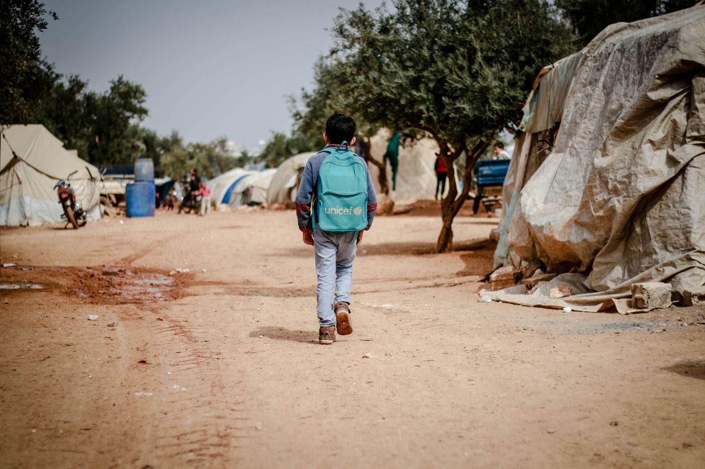 Illustrative photo: a child with a school bag walking to school
